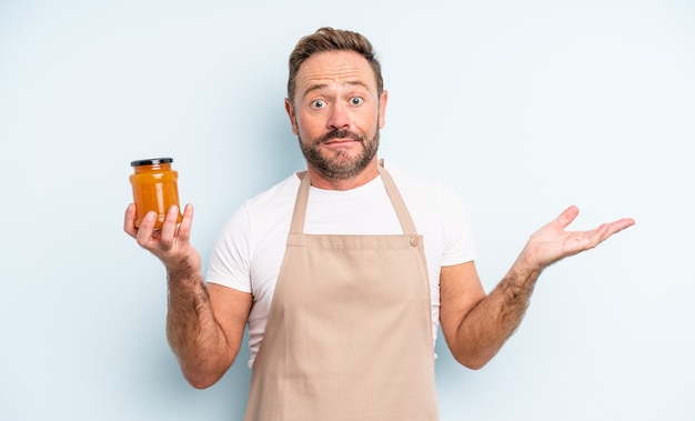 Middle age handsome man feeling puzzled and confused and doubting. peach jam concept