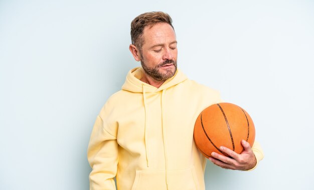 Middle age handsome man feeling sad, upset or angry and looking to the side. basketball concept