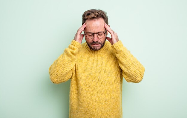 Middle age handsome man looking stressed and frustrated, working under pressure with a headache and troubled with problems