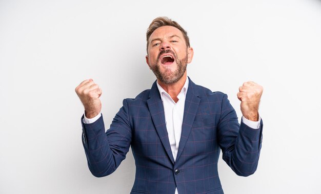 Middle age handsome man shouting aggressively with an angry expression. businessman concept