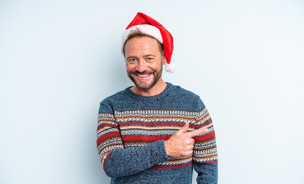 Middle age handsome man smiling cheerfully, feeling happy and pointing to the side. christmas concept