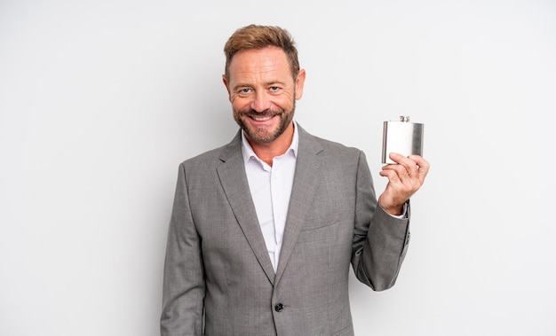 Middle age handsome man smiling happily with a hand on hip and confident. alcohol flask concept