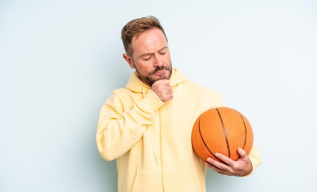 Middle age handsome man thinking, feeling doubtful and confused. basketball concept