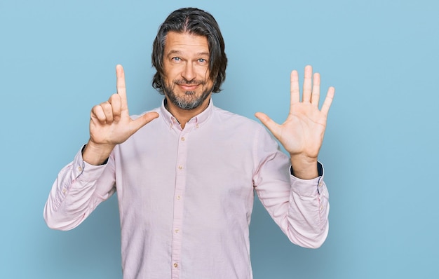 Photo middle age handsome man wearing business shirt showing and pointing up with fingers number seven while smiling confident and happy.