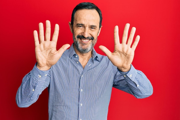 Photo middle age hispanic man wearing casual clothes showing and pointing up with fingers number ten while smiling confident and happy