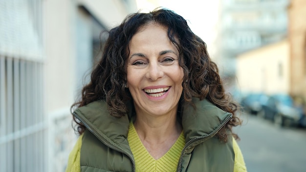 Middle age hispanic woman smiling confident at street