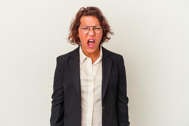 Middle age latin business woman isolated on white background screaming very angry and aggressive.