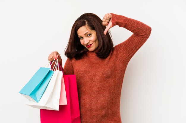 Middle age latin woman holding a shopping bags isolated feels proud and self confident, example to follow.