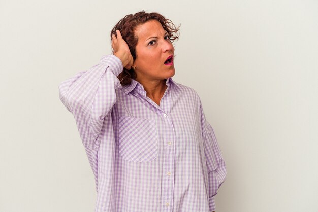 Middle age latin woman isolated on white background being shocked, she has remembered important meeting.