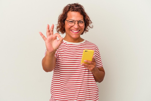 Middle age latin woman isolated on white background cheerful and confident showing ok gesture.