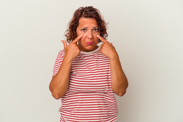 Foto donna latina di mezza età isolata su sfondo bianco che piange, infelice con qualcosa, agonia e concetto di confusione.