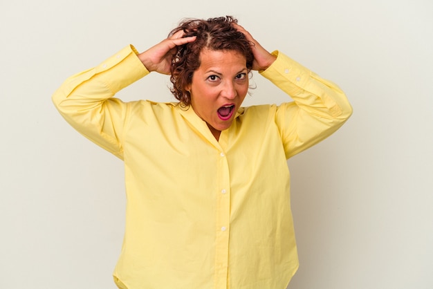 Photo middle age latin woman isolated on white background screaming, very excited, passionate, satisfied with something.