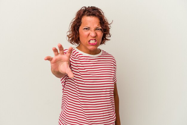 Middle age latin woman isolated on white background showing claws imitating a cat, aggressive gesture.