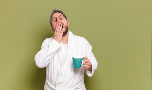 Uomo di mezza età che si sveglia con una tazza di caffè