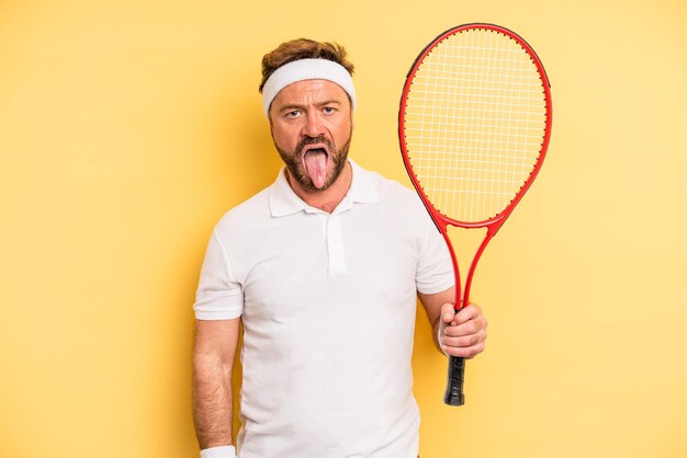 Middle age man feeling disgusted and irritated and tongue out tennis concept