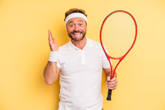 Middle age man feeling happy and astonished at something unbelievable. tennis concept