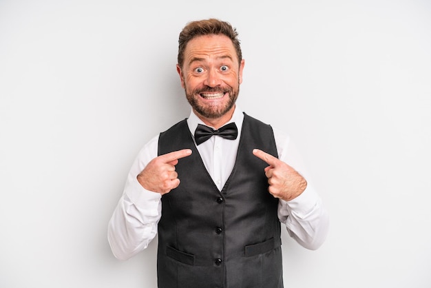 Middle age man feeling happy and pointing to self with an excited waiter concept