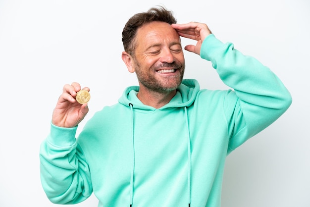 Middle age man holding a Bitcoin over isolated background smiling a lot