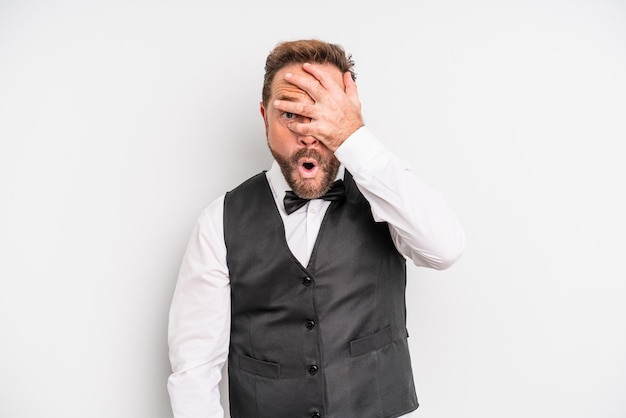 Middle age man looking shocked, scared or terrified, covering face with hand. waiter concept