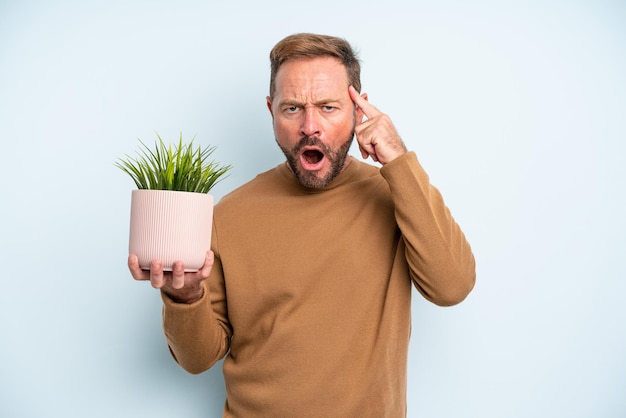 驚いた中年の男性は、新しい考え、アイデア、または概念を実現します。植木鉢のコンセプト