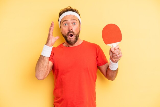 Middle age man screaming with hands up in the air. ping pong concept