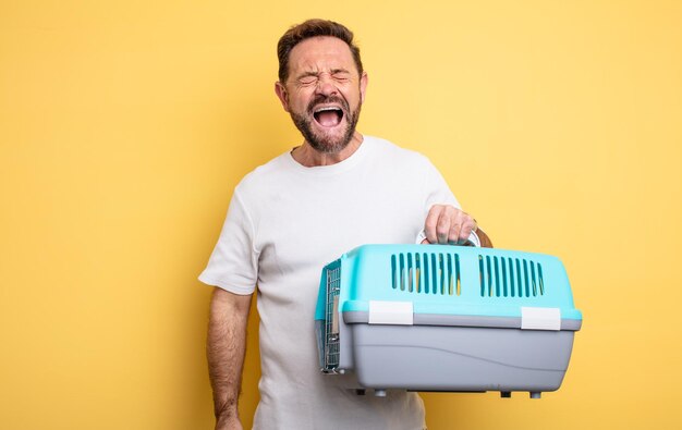 Middle age man shouting aggressively, looking very angry. pet carrier concept