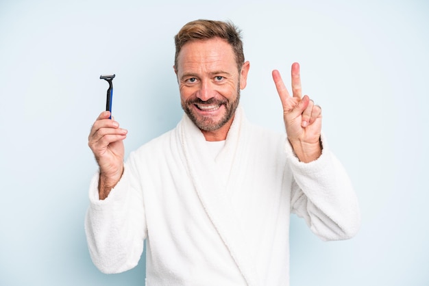 Middle age man smiling and looking friendly, showing number two. shave concept