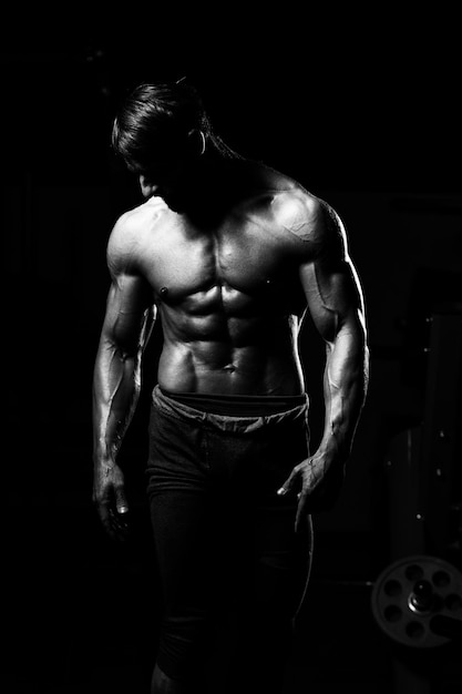 Middle Age Man Standing Strong In The Gym And Flexing Muscles - Muscular Athletic Bodybuilder Fitness Model Posing After Exercises