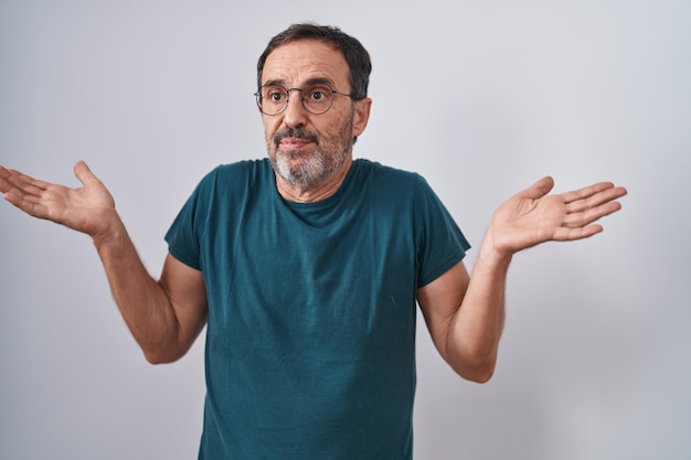 Middle age man standing with doubt expression over isolated white background