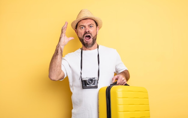 Middle age man tourist screaming with hands up in the air. travel concept