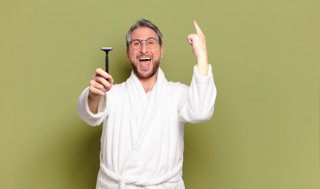 Middle age man wearing bath robe and a razor