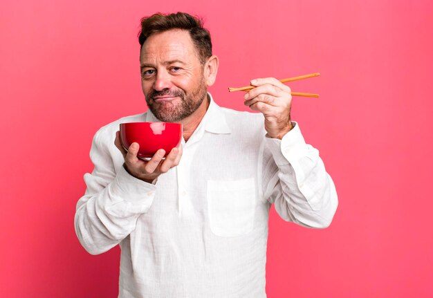 Middle age man with a chinese noodles bowl sport coach concept with a soccer ball