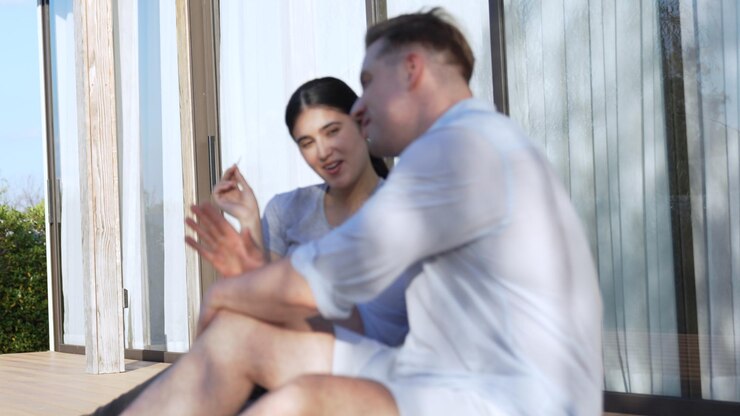 Photo 中年夫婦が屋外のテラスでリラックスししゃべっています
