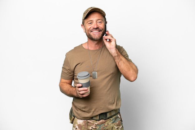 Middle age military with dog tag isolated on white background holding coffee to take away and a mobile