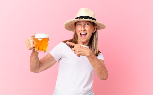 Mezza età bella donna in pensione che beve una birra in vacanza?