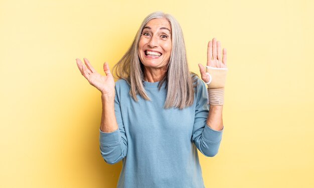 Middle age pretty woman feeling happy, surprised realizing a solution or idea. hand bandage concept