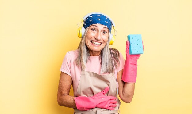 Middle age pretty woman laughing out loud at some hilarious joke. scourer cleaner