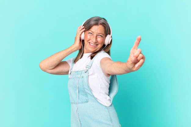 Middle age pretty woman listening music with a headphones