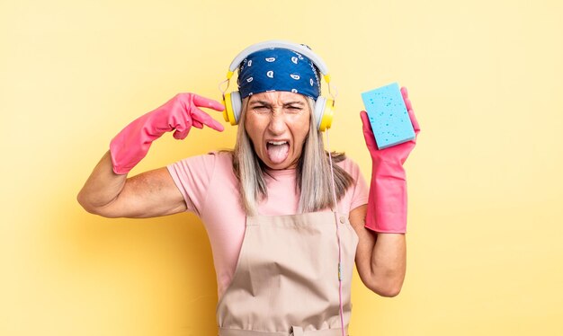 Middle age pretty woman looking unhappy and stressed, suicide gesture making gun sign. scourer cleaner