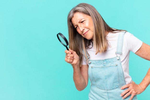 Middle age pretty woman with a magnifying glass search concept