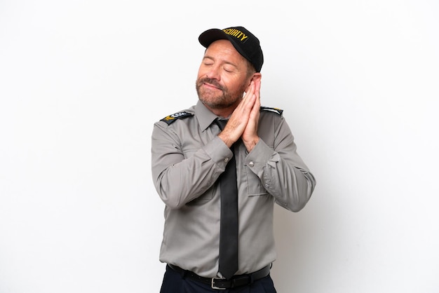 Middle age security man isolated on white background making sleep gesture in dorable expression