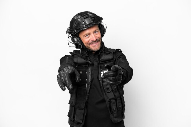 Middle age SWAT man isolated on white background points finger at you while smiling