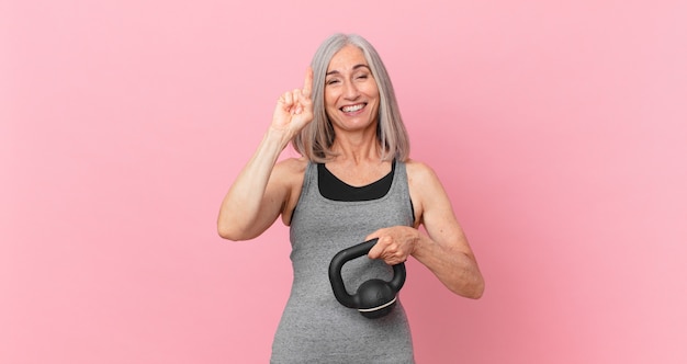 Middle age white hair woman lifting a dumbbell. fitness concept