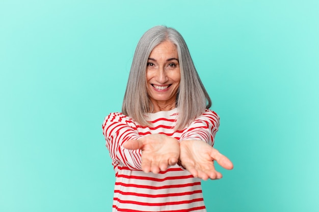 Middle age white hair woman smiling happily with friendly and  offering and showing a concept