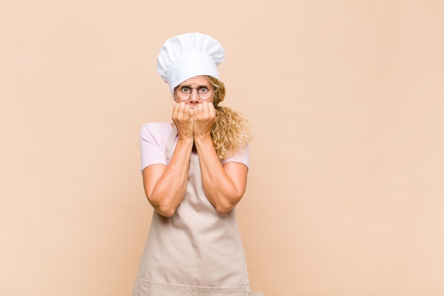 Middle age woman baker looking worried, anxious