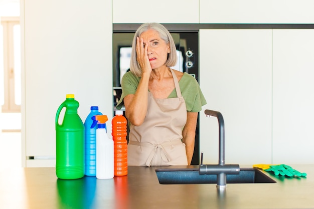 Middle age woman feeling bored, frustrated and sleepy after a tiresome, dull and tedious task, holding face with hand