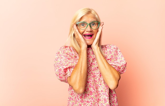 Middle age woman feeling disgusted, holding nose to avoid smelling a foul and unpleasant stench