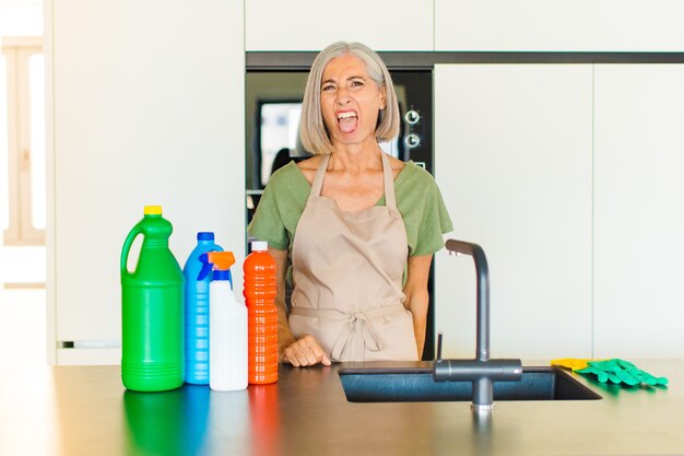 Middle age woman feeling disgusted and irritated, sticking tongue out, disliking something nasty and yucky