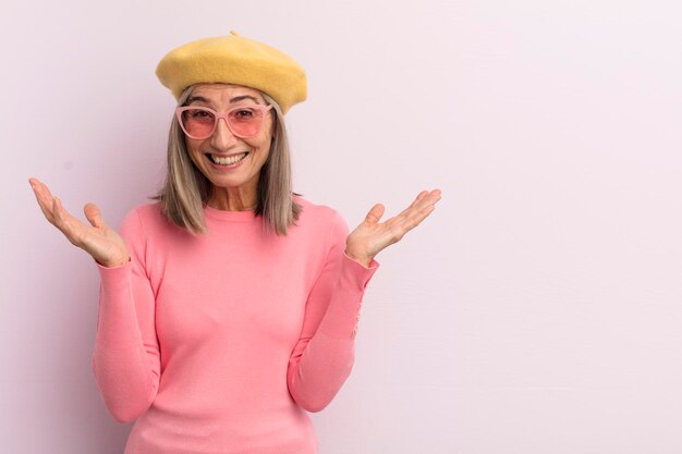 Middle age woman feeling happy and astonished at something unbelievable