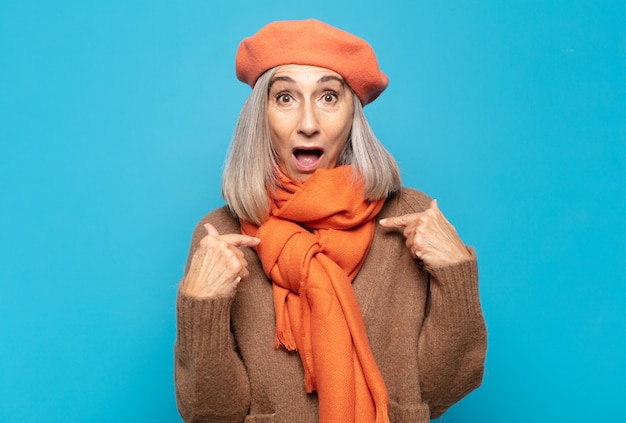 Photo middle age woman feeling happy, surprised and proud, pointing to self with an excited, amazed look